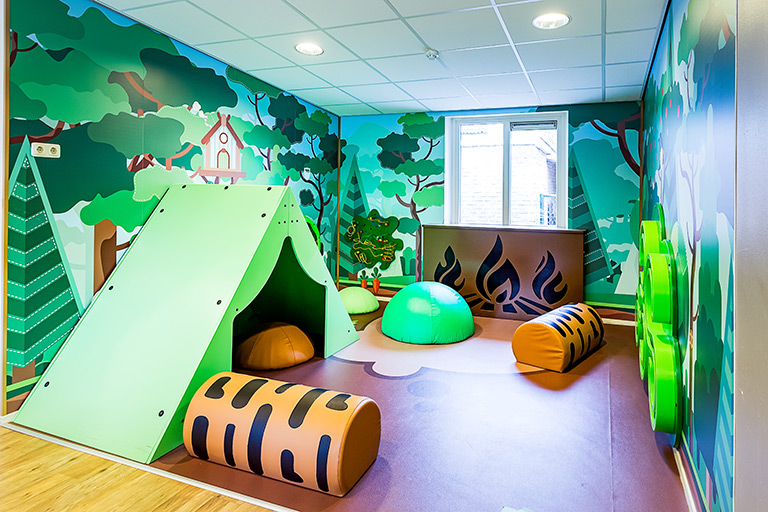 Inrichting kinderdagverblijf met een camping thema met wandspellen en softplay kussens en een tent Inrichting kinderdagverblijf met een camping thema met wandspellen en softplay kussens en een tent